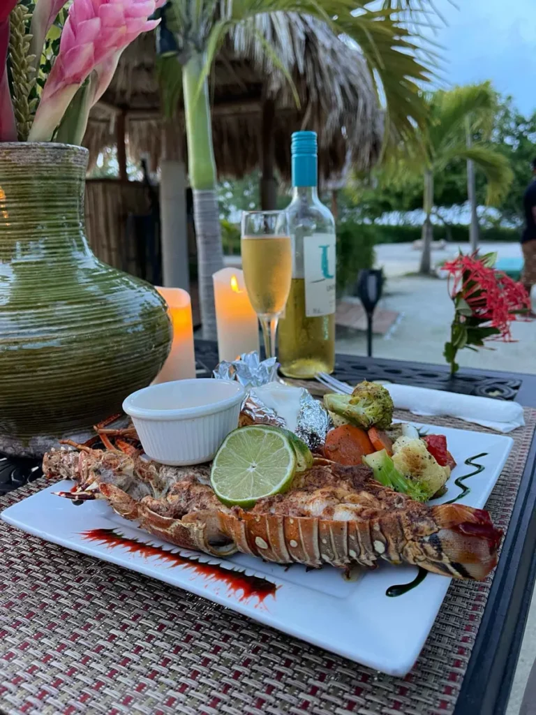 lobster menu during the appropriate season in Belize at little peter oasis, a private island rental, prepared by a private island chef with some wine on the beach 