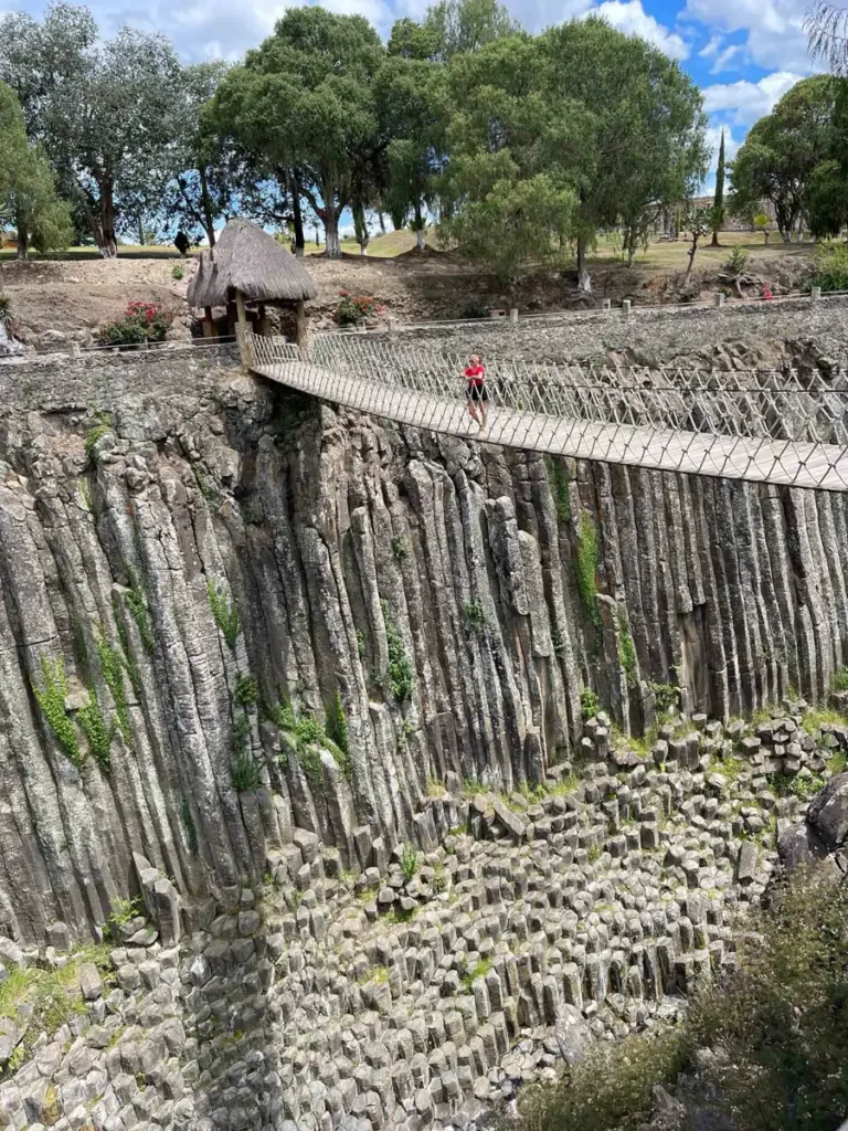 rocky canyon with geometrical formed rocks with a bridge in a dry landscape, Prismos Basalticos de Santa Maria Regla in Hidalgo Mexico, ideal for a perfect Mexico itinerary