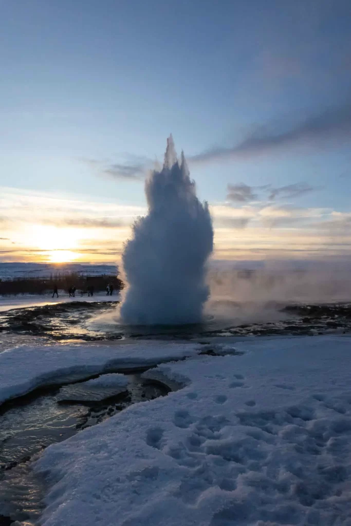 active geysire strokkur in a snowy landscape at sunset in iceland