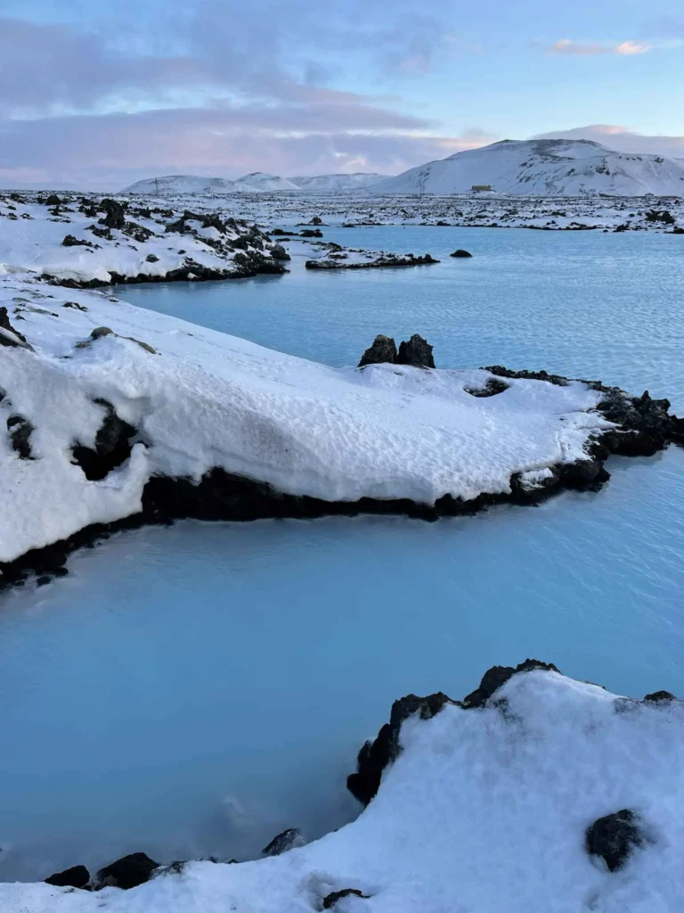 volcanic blue lagoon with blue water surrounded by a snowy landscape in iceland