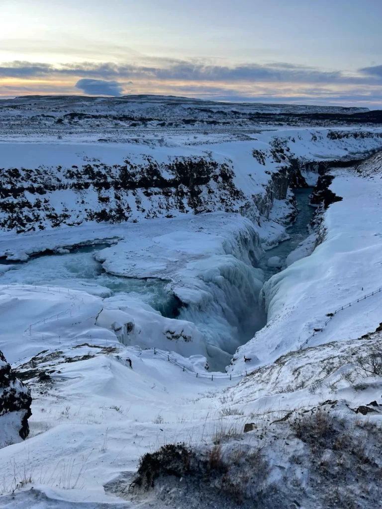 frozen waterfall in a snowy and rocky landscape at gullfoss waterfall in iceland