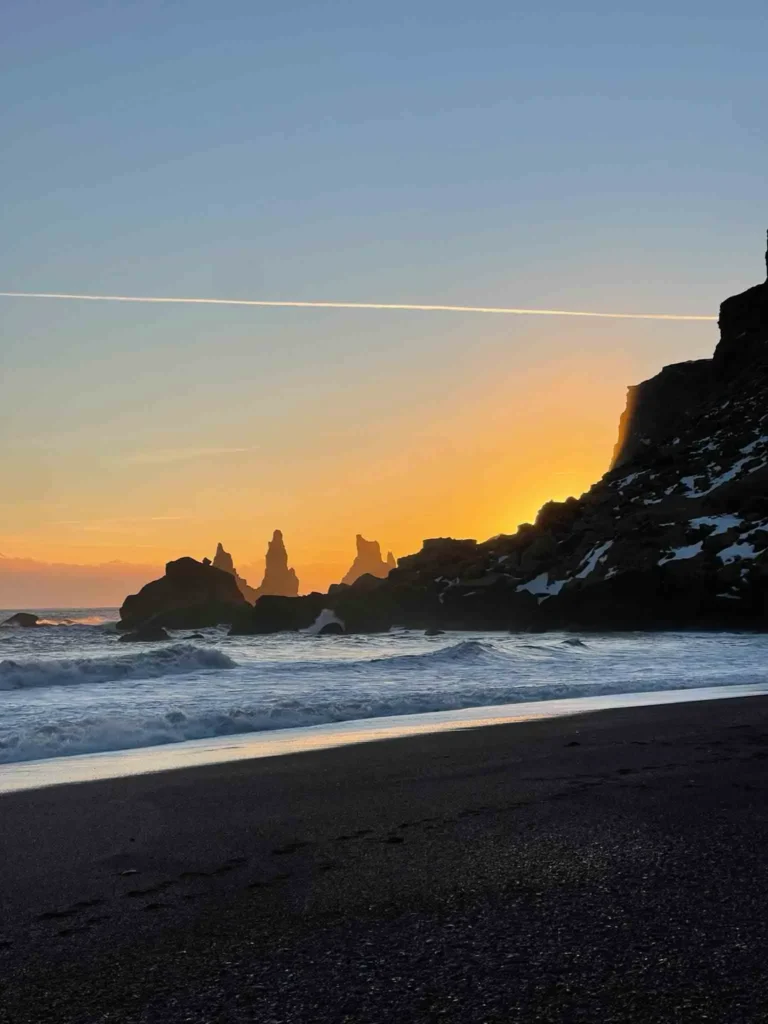 Vik Black Sand Beach, hidden gems in Iceland black sand beach with waves black rocky terrain at sunset at vik beach in iceland