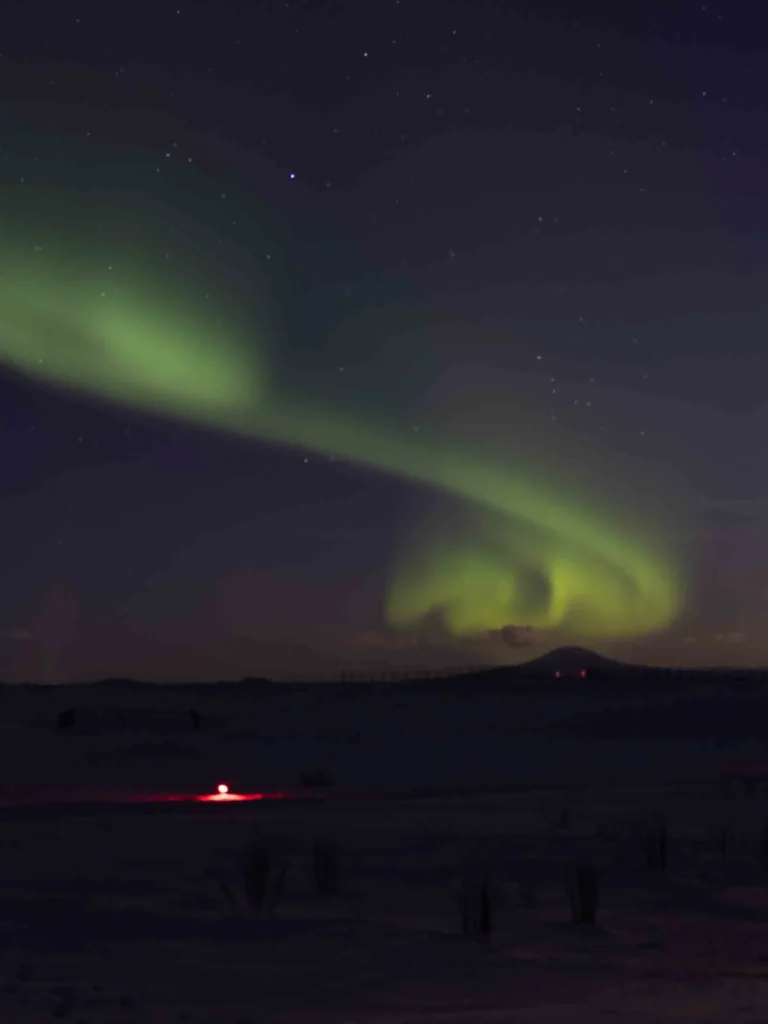green northern lights forming a spiral
