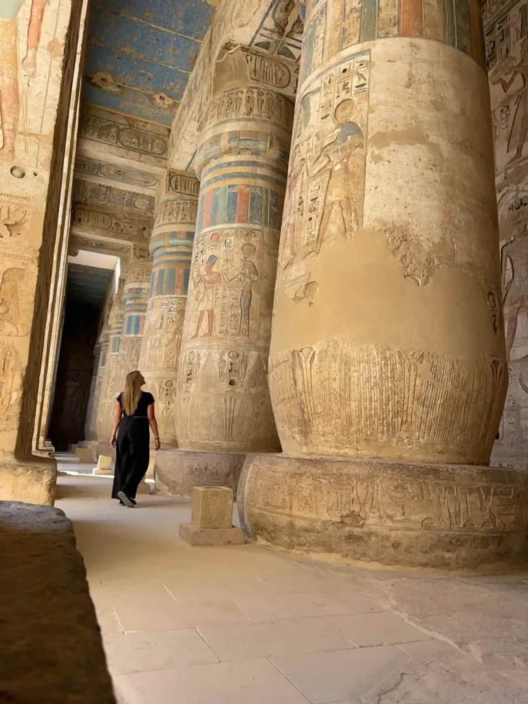 woman walking through an ancient temple with colourful columns
