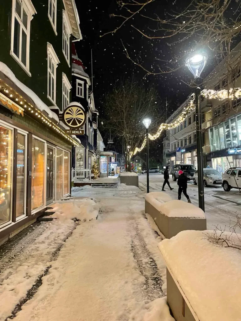a street in a small city with charming christmas lights at night in the capital of north akureyri in iceland