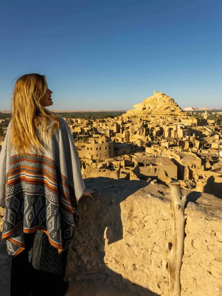 woman overlooking an ancient town made of mud