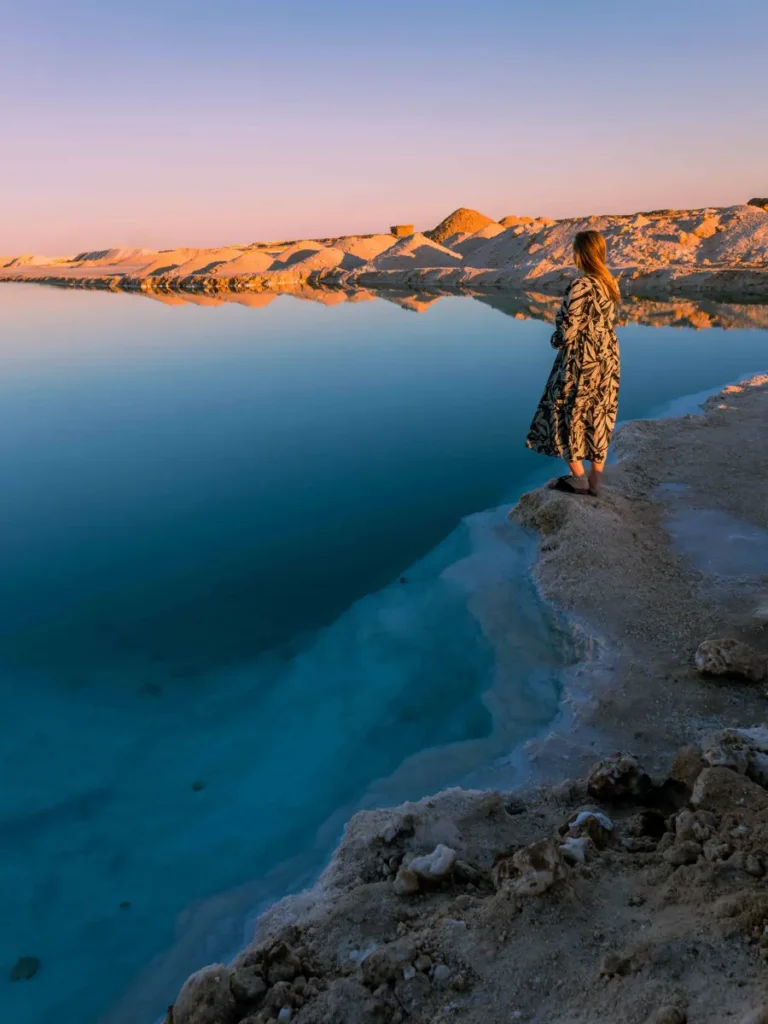 woman in a dress overlooking a salt lake during sunset