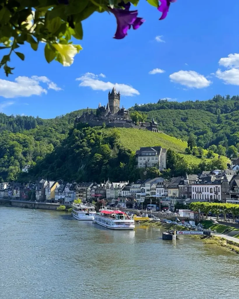A colourful town with a majestic castle on a hill overlooking the river valley, town and surrounding hills in Cochem, Germany