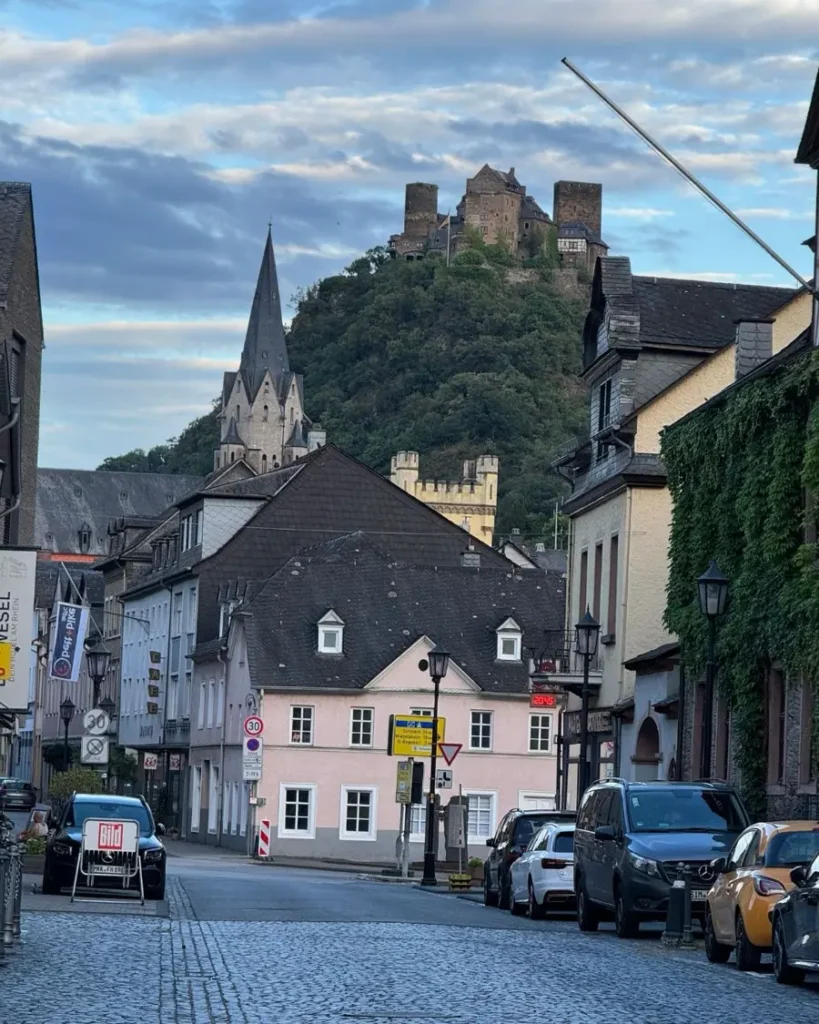 Old town with traditional houses, cobble stone roads, a church and hillside castle in Oberwesel along the Rhine river in Germany