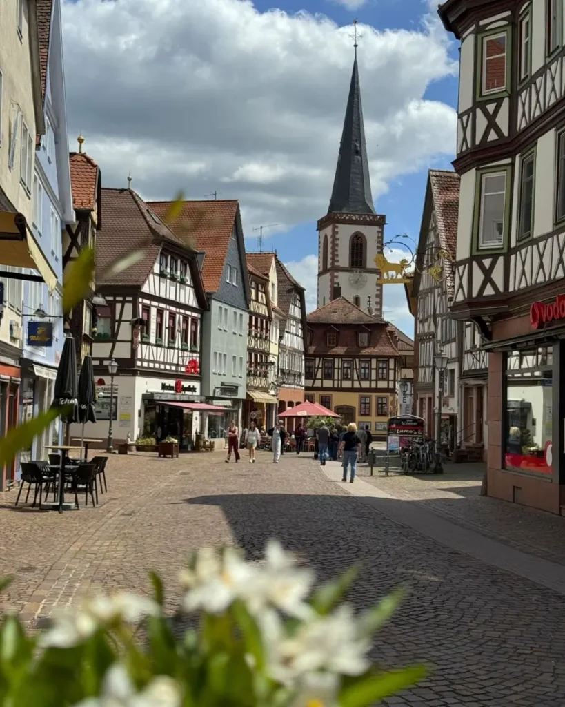 Beautiful view of an old town with cobblestone roads, a church and traditional half-timbered houses in Lohr am Main, Germany
