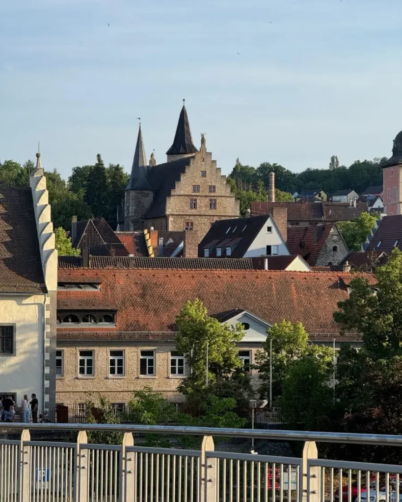 View of a historic town with multiple towers and beautiful architecture from a bridge above the Main in Ochsenfurt, Germany