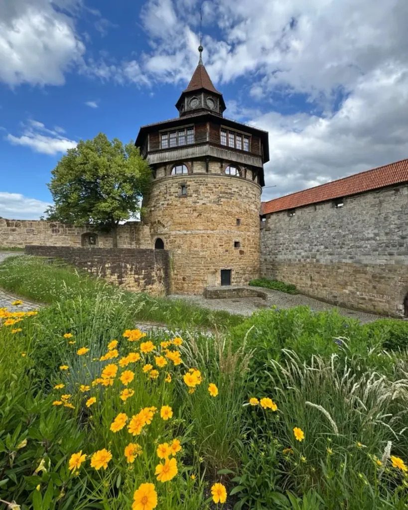 Unique castle tower of a medieval castle surrounded by a garden with flowers and city walls in Esslingen am Neckar
