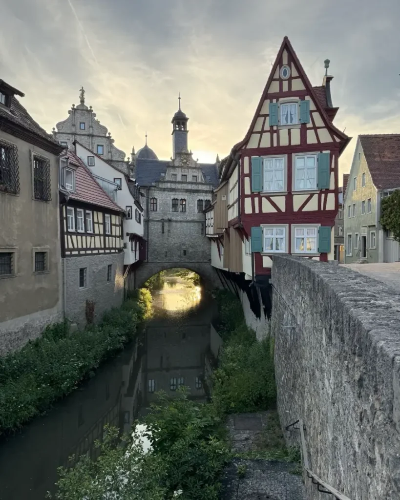 Historic bridge over a small river with a building on top and traditional half-timbered houses on each side im Marktbreit - a hidden gem in Germany