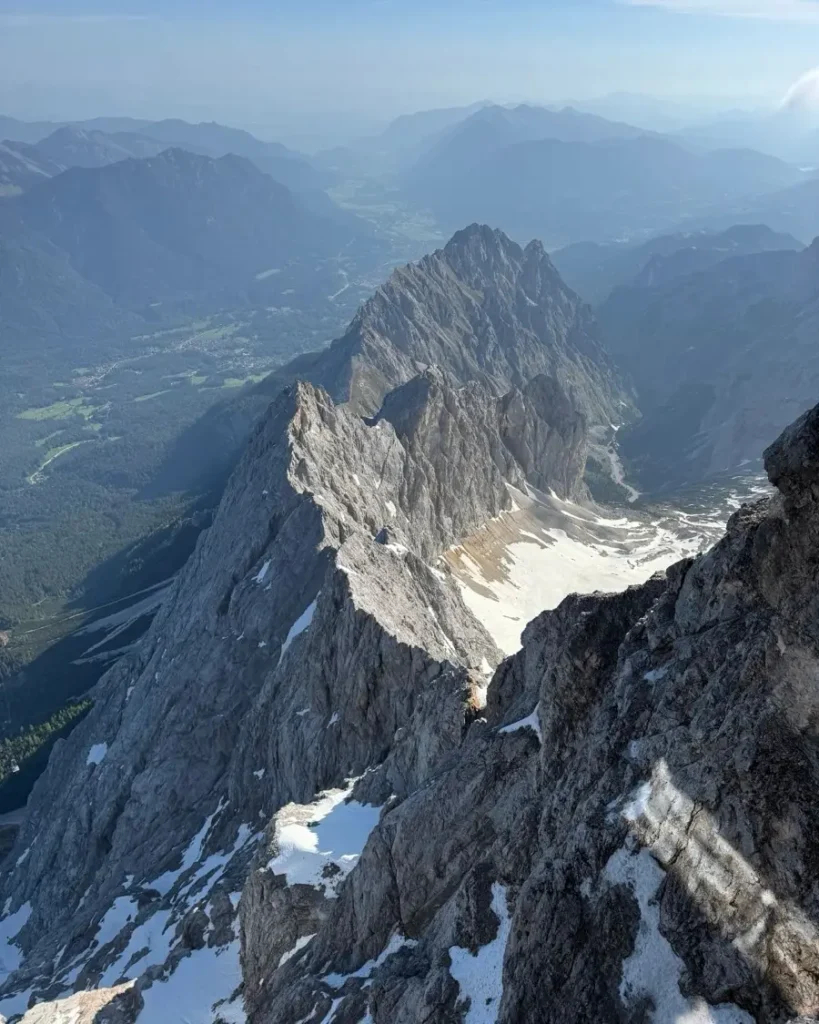 dramatic mountain view from the top of Germany's highest mountain the Zugpsitze with rocky surfaces, some snow and fog
