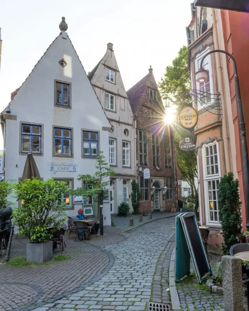 Rising sun between traditional houses with high roofs in Bremen's Schnoor quarter - a charming part of the old town with cobble stone roads and beautiful houses