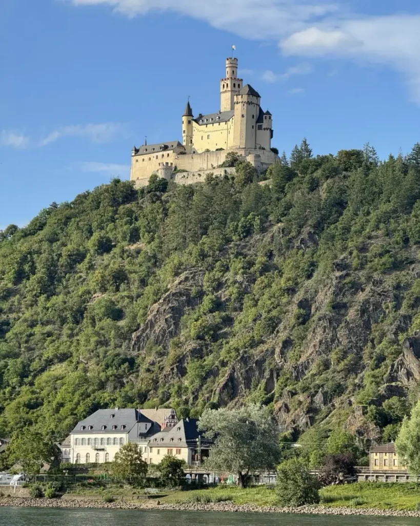 Large castle on top of a hill above a little charming town along the Rhine river in Germany