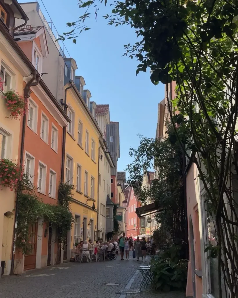 Red roses in the foreground of a beautiful old town with a line of colourful houses and cobblestone roads in Lindau at Lake Contance