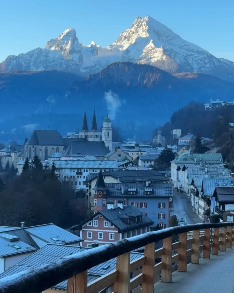 View from a hillside road of a beautiful town and massive mountains in the backdrop in Berchtesgaden, Germany