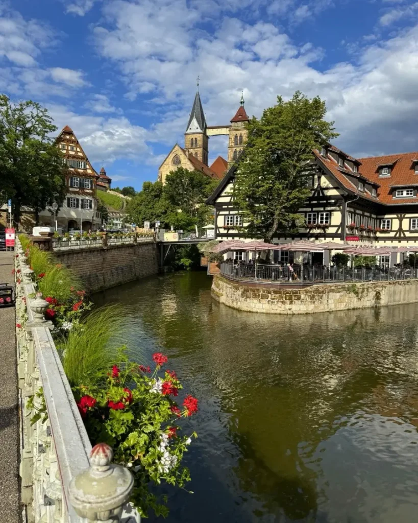 Historic old town view of a church with two identical towers and a half-timbered house built on a man-made island on the Neckar in Esslingen