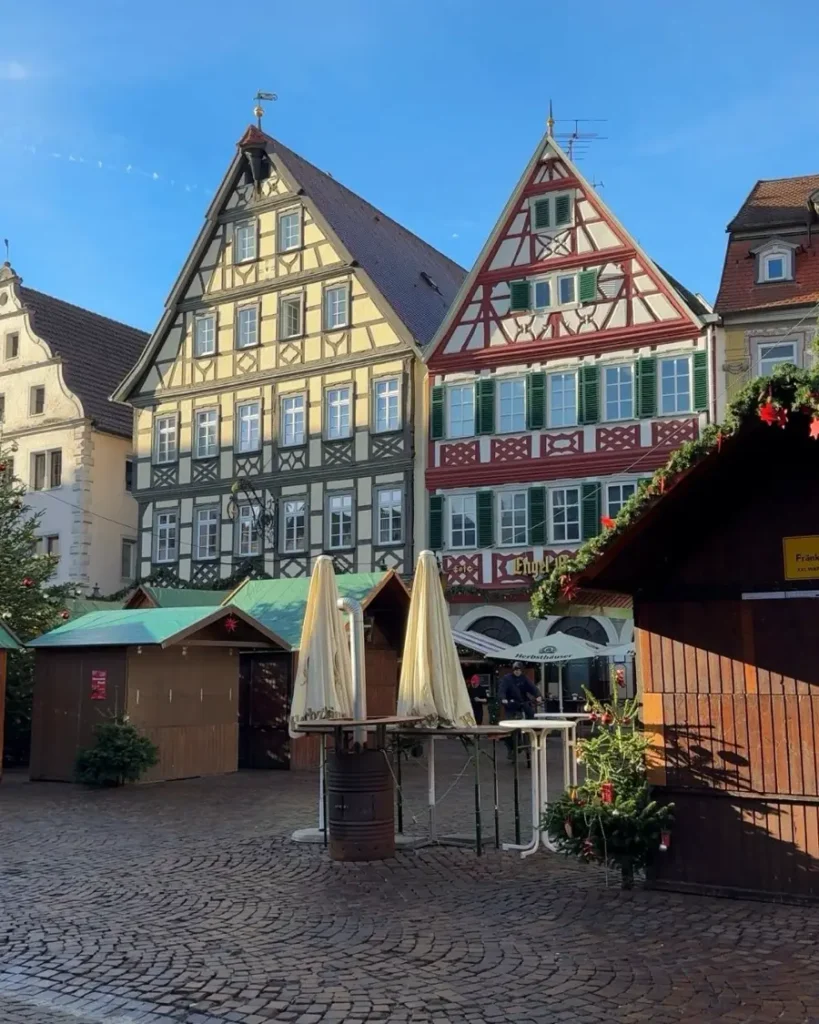 Colourful half-timbered houses on a cobblestone road in the fairytale town of Bad Mergentheim with some closed Christmas market stalls
