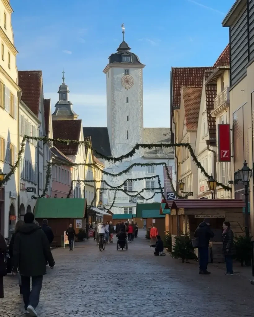 A cobblestone road leading to a church at the end of it with christmas decorations and vendor stalls on both sides in Bad Mergentheim, Germany