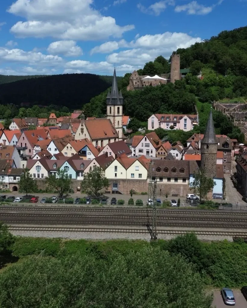 bird's eye view of a medieval town with a historic tower, church and castle ruins with train tracks in Gemünden am Main, Germany
