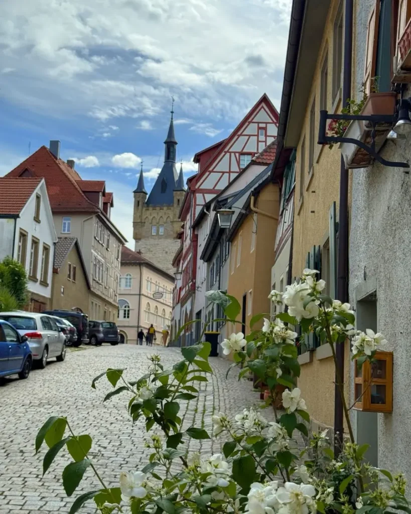 Cobblestone road leading to a medieval tower with a unique roof surrounded by beautiful houses in the fairytale town of bad Wimpfen