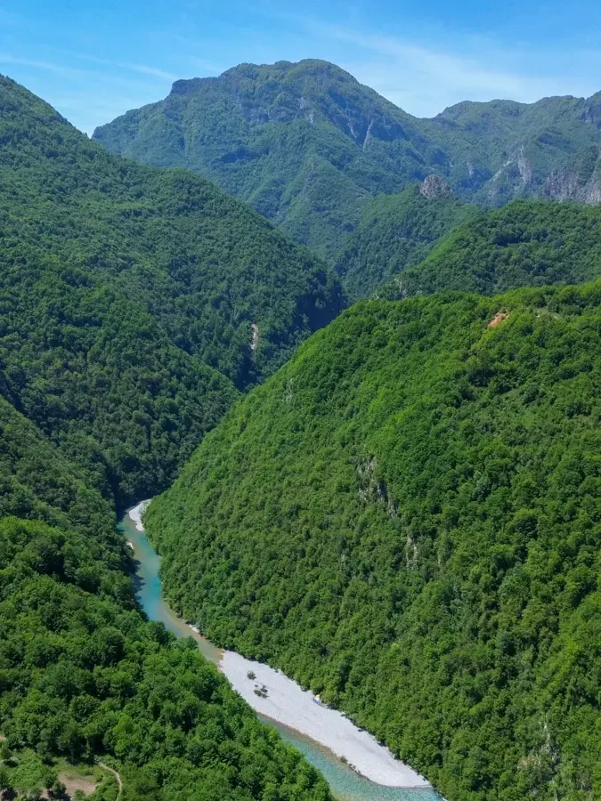 bird's eye view of a blue river making it's way through a deep and very lush canyon