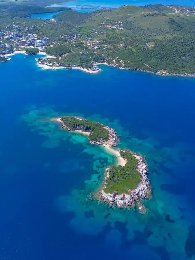 bird's eye view of an island just off the shores of Ksamil, with beautiful blue water: a must stop on your Albania itinerary