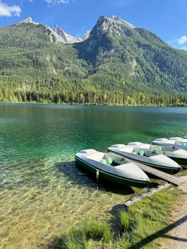 A beautiful mountain lake with clear, green water, a few boats and mountains in the background -Hintersee, Bavaria