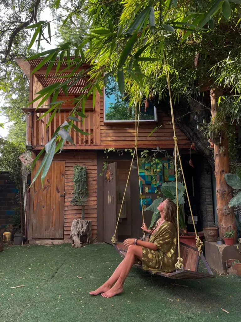 incredible unique stay in Mexico – Huamuchil Treehouse in Oaxaca City wooden treehouse an incredible unique stay in Mexico - Huamuchil Treehouse in Oaxaca City with a woman sitting on a big sling surrounded by mexican nature