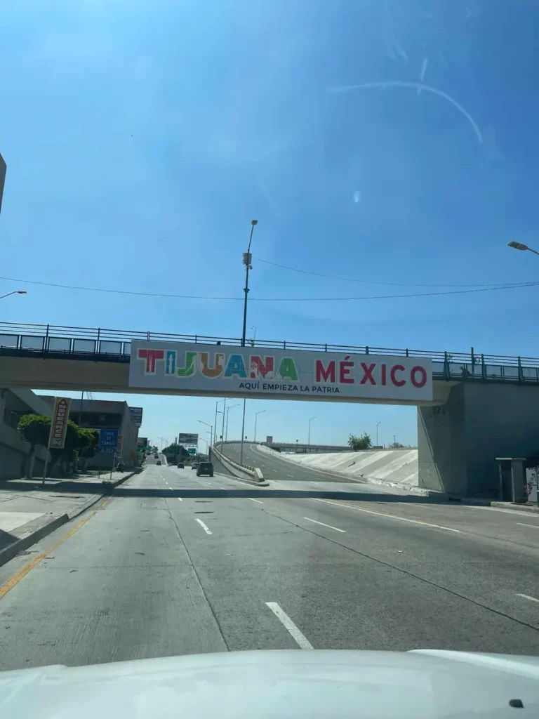 bridge over a highway with a a sign tijuana mexico photo is taken from the car