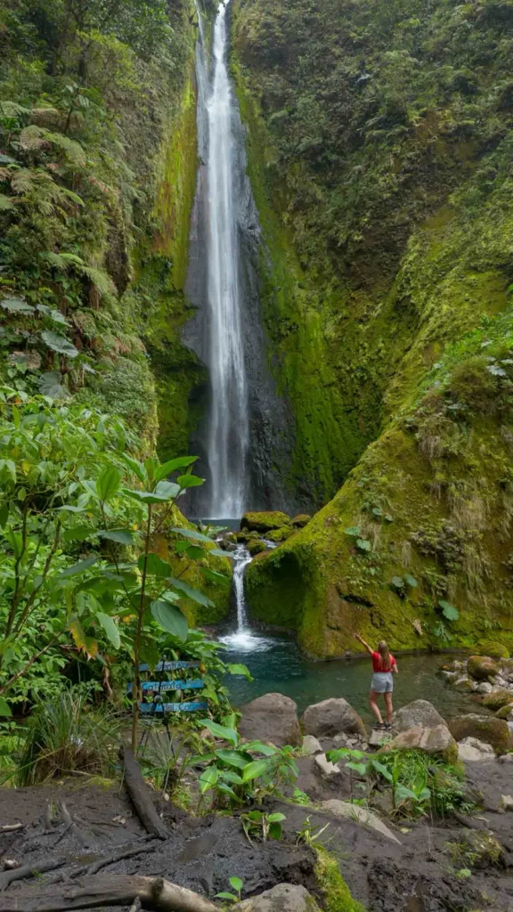 Catarata Vuelta del Canon waterfall with multiple layers of the waterfall and formed pools surrounded by rocks, overgrown rocks and jungle landscape in bajos del toro in costa rica