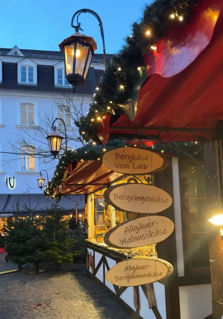 Christmas market stall with wooden signs for available food options in Saarbrücken, Germany