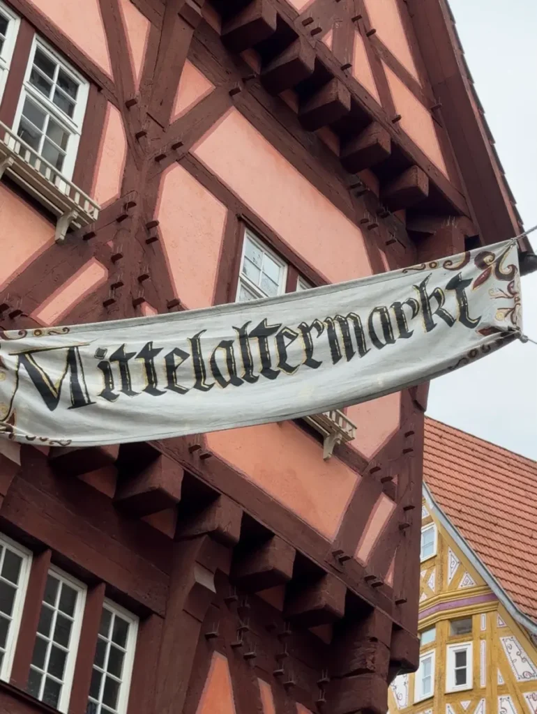 A sign with "Mittelaltermarkt" hanging between half-timbered houses in Esslingen, Germany