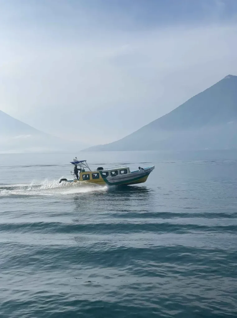 boat at lake atitlan with volcanoes in the back in guatemala