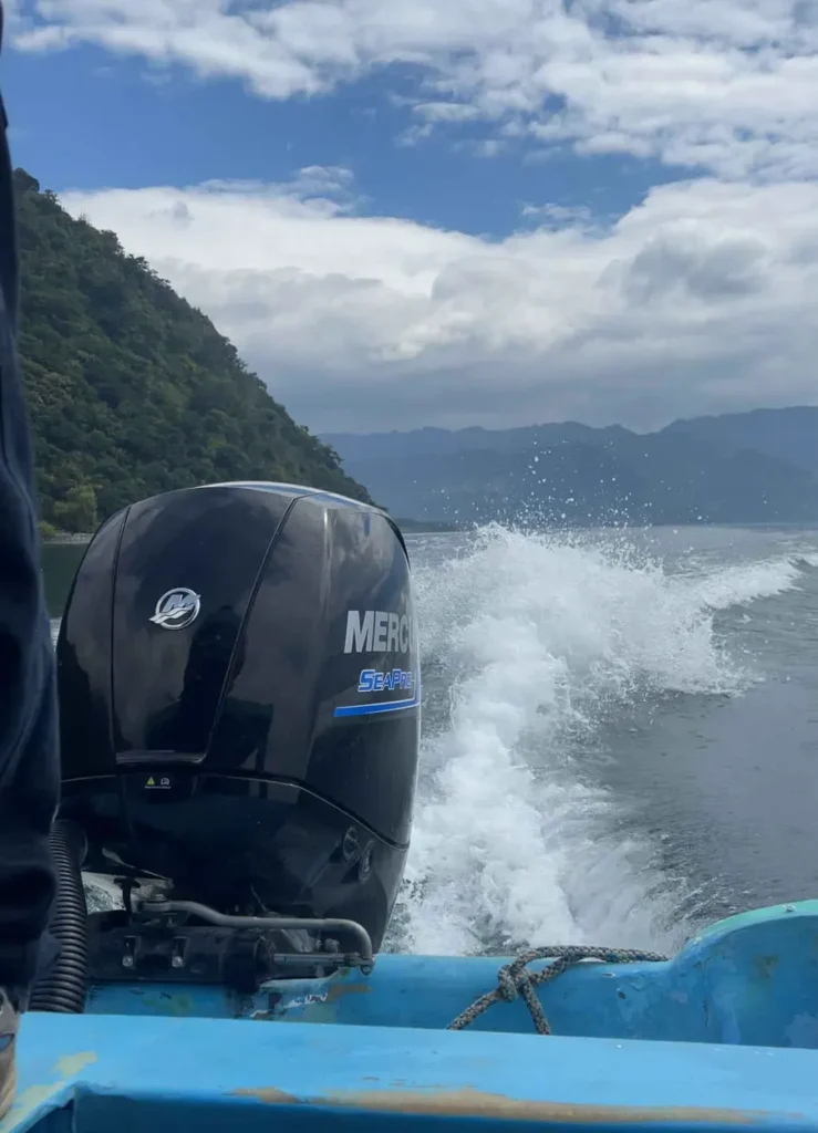 motor of a boat on lake atitlan in guatemala with surrounding mountains and volcanoes