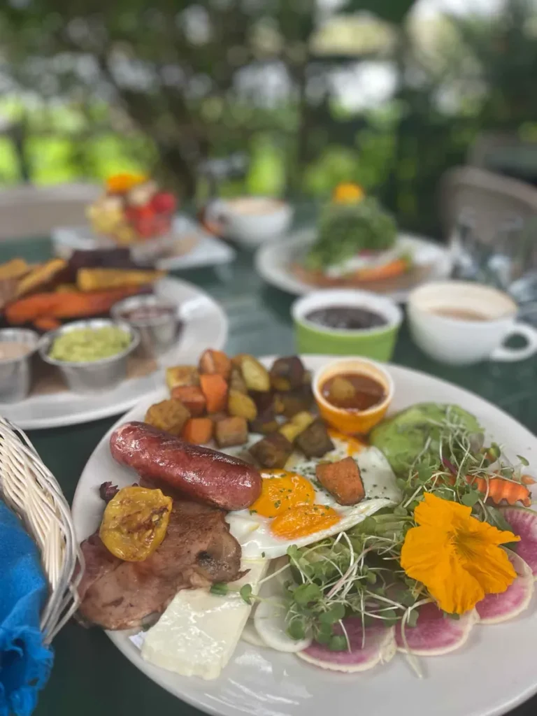 plated table with plates with delicious food and coffee cups with some greenery in the back at brunch at Caoba farms in antigua guatemala