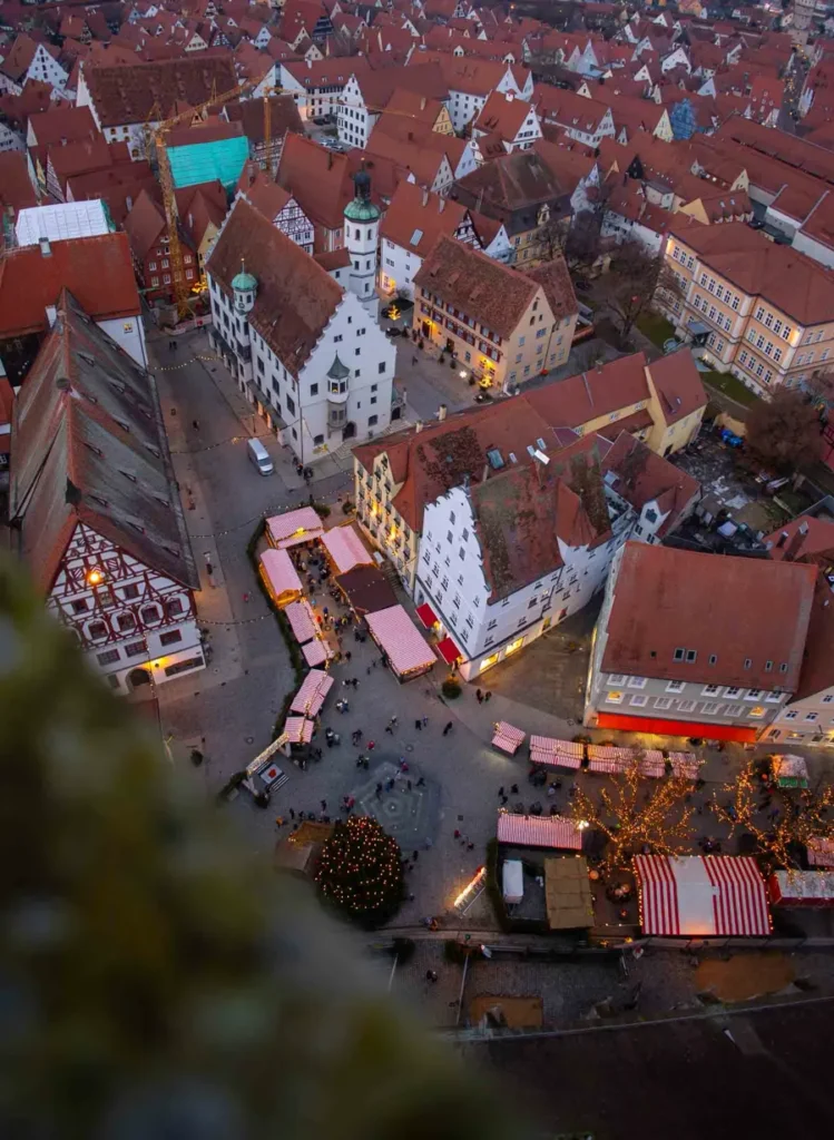 Bird's eye view of a medieval old town with traditional buildings and Christmas market stalls along the main road in Nördlingen