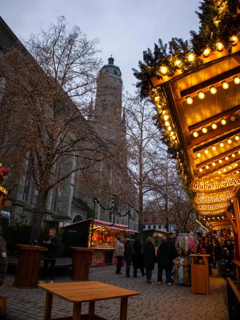 View of a Gothic chruch and christmas market stalls with tables in Nördlingen, Germany