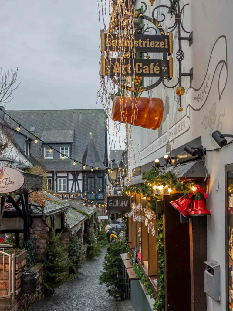 Charming alley with traditional half-timbered houses, signs and Christmas decorations in Rüdesheim am Rhein