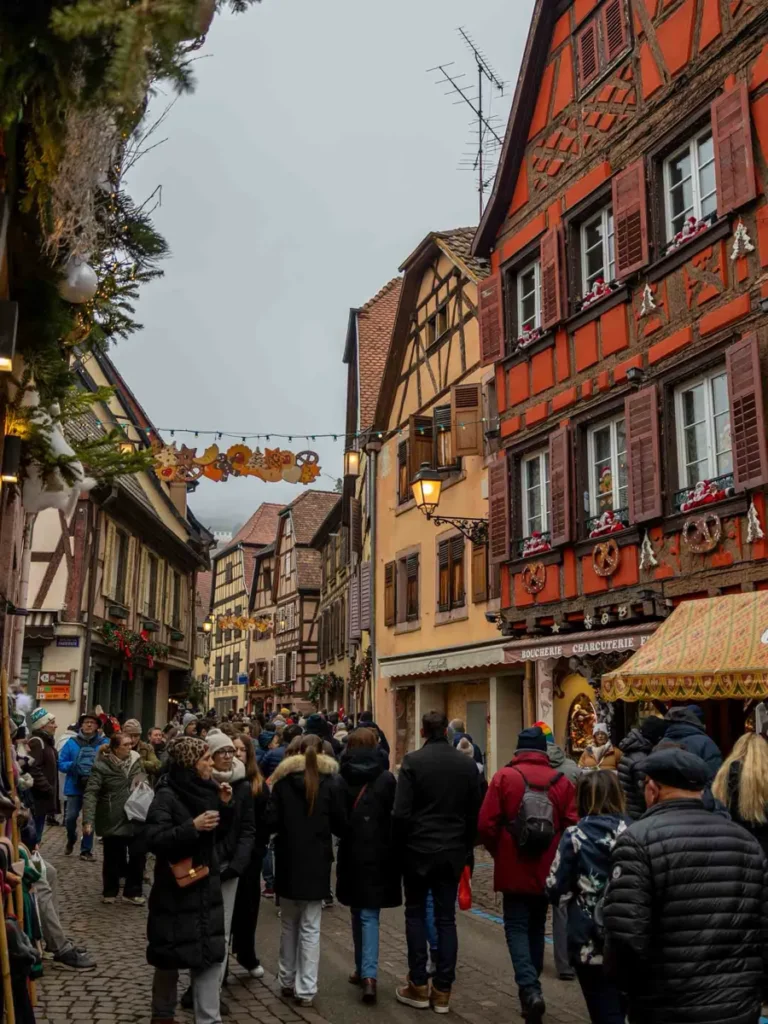 Street surrounded by colourful hlaf-timbered houses and christmas decorations in Ribeauvillé, Alsace