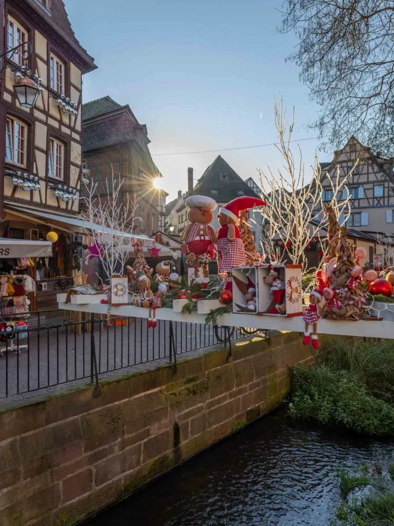 Christmas decorations over a canal in Colmar with one of the most beautiful Christmas markets in Alsace