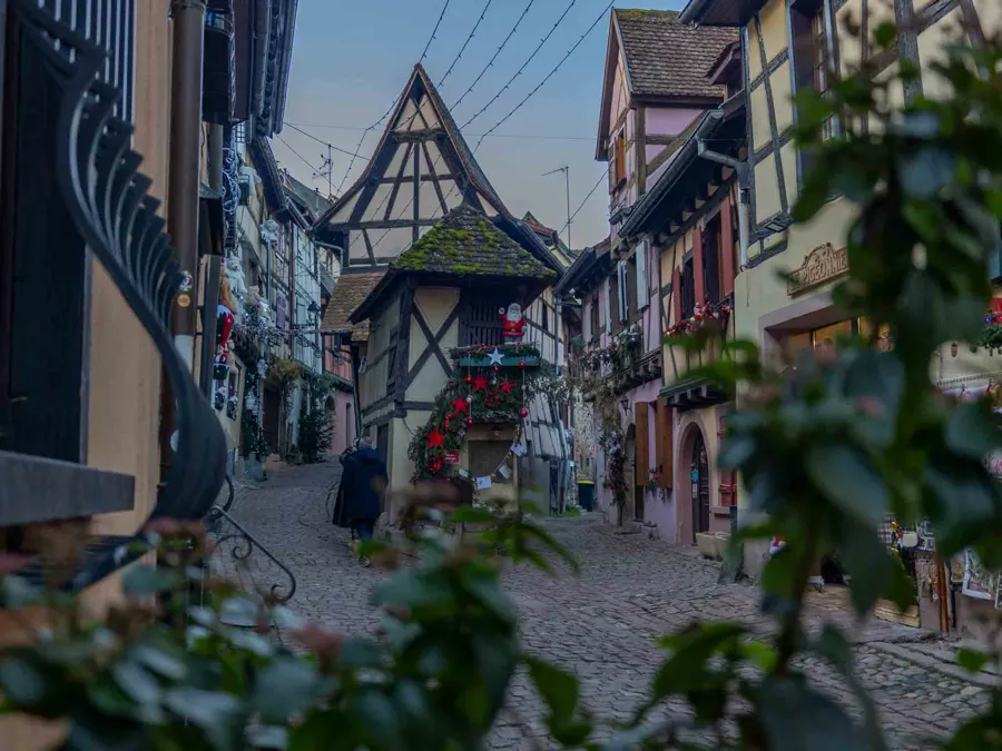 Cobblestone road with traditional half-timbered houses in Eguisheim, Alsace