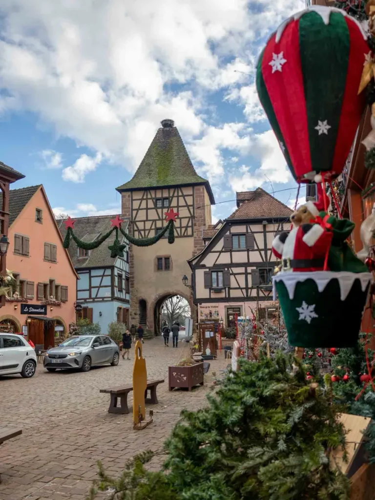 A medieval old town with half-timered houses, cobblestone roads, a medieval gate tower and christmas decorations in Turckheim, Alsace