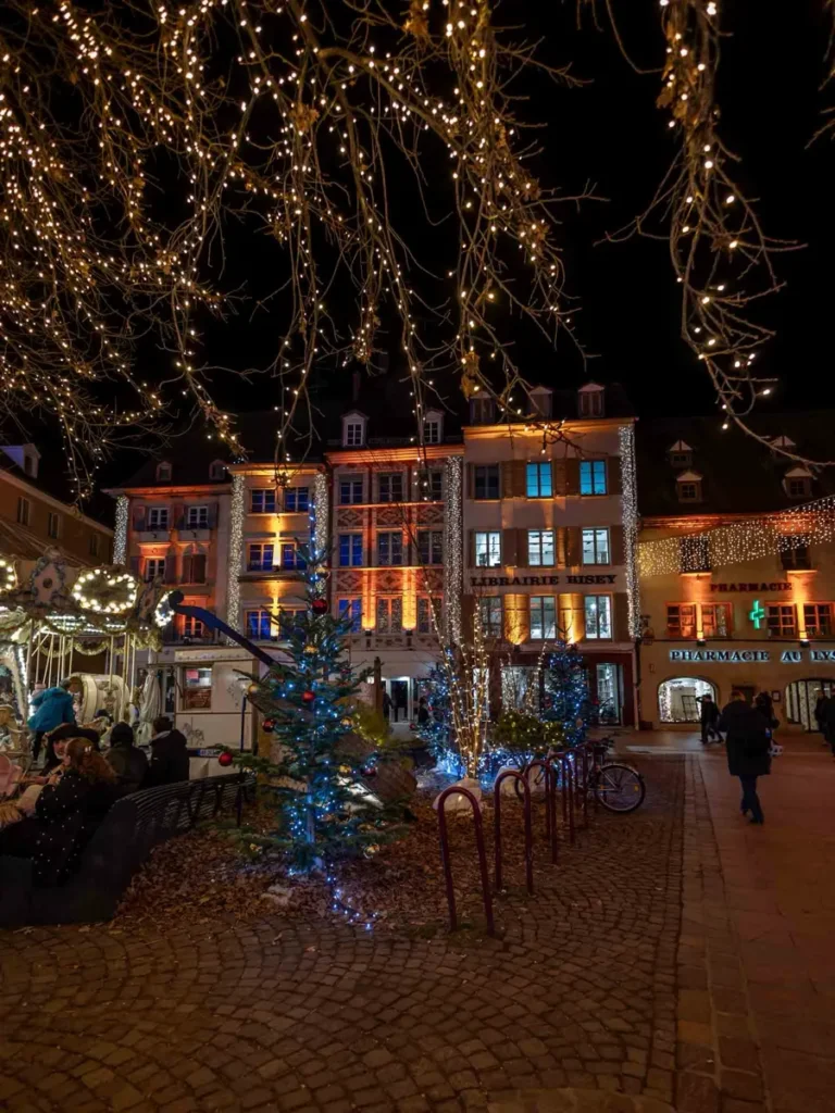 Illuminated historic houses on a square in the center in Mulhouse, France during Christmas time