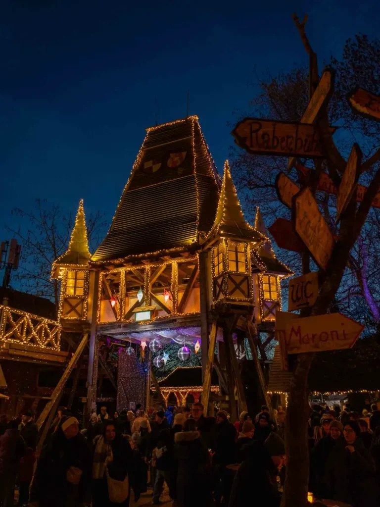 Medieval castle entrance gate illuminated by Christmas decorations at a Christmas market at Schloss Kaltenberg, Germany